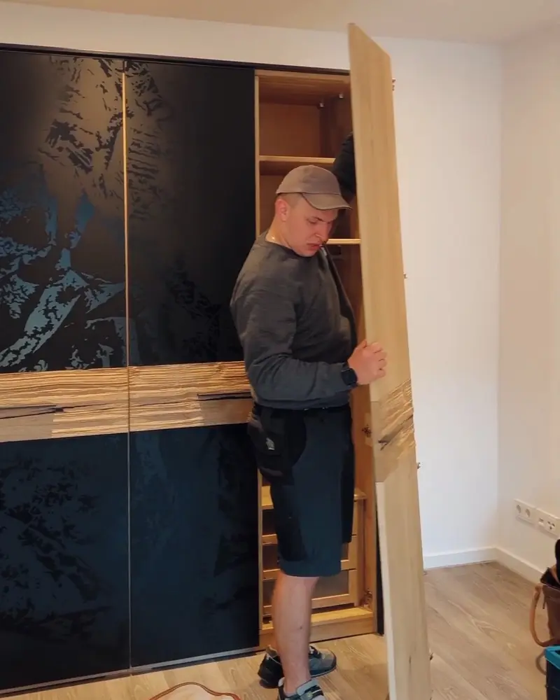 KVK-Mitarbeiter trägt ein Schrankteil bei der Arbeit in einer Wohnung