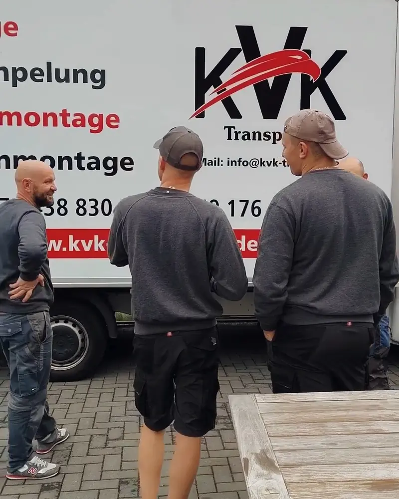 Drei Mitarbeiter von KVK vor dem beschrifteten KVK-Transporter